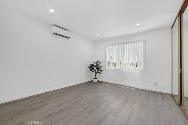 20930 Parthenia St Unit 206, Canoga Park, CA 91304 - spare room featuring an AC wall unit, wood finished floors, recessed lighting, and baseboards
