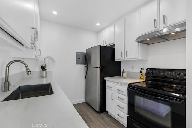 20930 Parthenia St Unit 206, Canoga Park, CA 91304 - kitchen with black electric range oven, a sink, under cabinet range hood, freestanding refrigerator, and white cabinetry