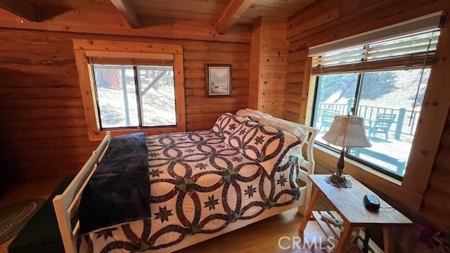 33796 Cedar Pines Ln, Green Valley Lake, CA 92341 - bedroom featuring access to outside, wood finished floors, wood walls, and wood ceiling with exposed beams