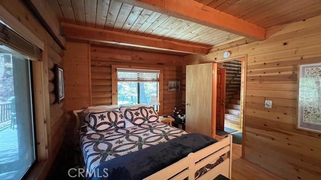 33796 Cedar Pines Ln, Green Valley Lake, CA 92341 - bedroom with wood ceiling with exposed beams, wooden walls, and wood finished floors