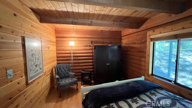 33796 Cedar Pines Ln, Green Valley Lake, CA 92341 - bedroom with wood ceiling with exposed beams, wood finished floors, and log walls