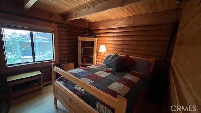 33796 Cedar Pines Ln, Green Valley Lake, CA 92341 - bedroom featuring rustic walls, wood ceiling with exposed beams, and wood finished floors