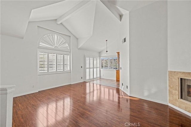 26966 Flo Ln Unit 318, Canyon Country, CA 91351 - unfurnished living room with wood finished floors, high vaulted ceiling, a tile fireplace, and beamed ceiling