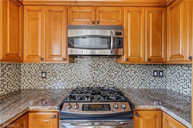 26966 Flo Ln Unit 318, Canyon Country, CA 91351 - kitchen featuring stainless steel appliances, backsplash, and brown cabinetry