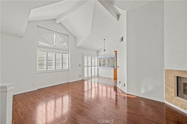 26966 Flo Ln Unit 318, Canyon Country, CA 91351 - unfurnished living room with wood finished floors, high vaulted ceiling, a tile fireplace, and beamed ceiling