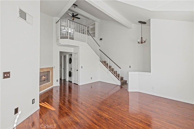26966 Flo Ln Unit 318, Canyon Country, CA 91351 - unfurnished living room with stacked washer / drying machine, wood finished floors, stairway, a ceiling fan, and beamed ceiling