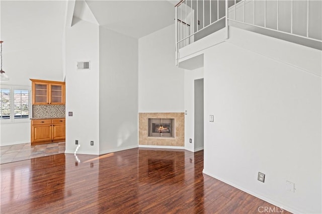 26966 Flo Ln Unit 318, Canyon Country, CA 91351 - unfurnished living room featuring a high ceiling, wood finished floors, and a tiled fireplace