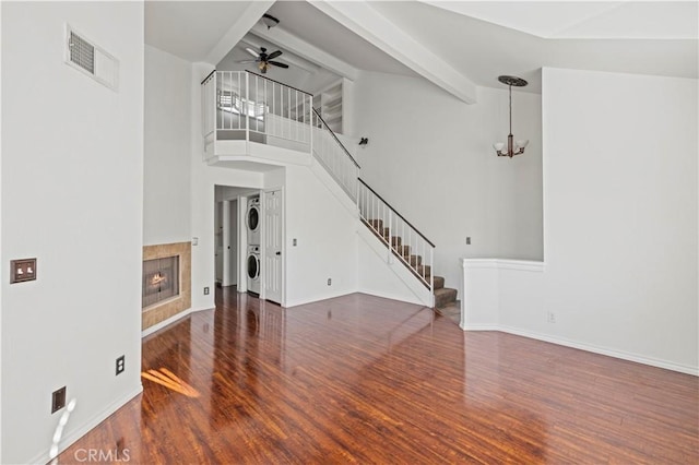 26966 Flo Ln Unit 318, Canyon Country, CA 91351 - unfurnished living room featuring stacked washing machine and dryer, wood finished floors, stairs, a ceiling fan, and beamed ceiling
