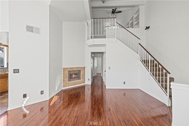 26966 Flo Ln Unit 318, Canyon Country, CA 91351 - unfurnished living room featuring ceiling fan, wood finished floors, stairway, a high ceiling, and a fireplace
