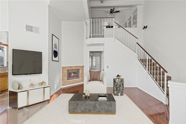 26966 Flo Ln Unit 318, Canyon Country, CA 91351 - living area featuring a ceiling fan, wood finished floors, stairway, a fireplace, and a towering ceiling