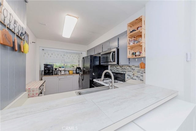 5493 Twin Lakes Dr, Cypress, CA 90630 - kitchen featuring stainless steel microwave, backsplash, freestanding refrigerator, range, and light countertops
