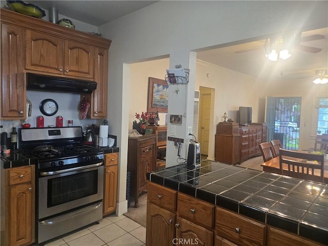 1121 Gladys Ave, Long Beach, CA 90804 - kitchen featuring gas range, under cabinet range hood, tile countertops, ceiling fan, and light tile patterned floors