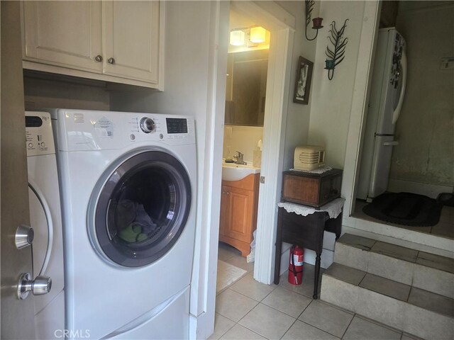 1121 Gladys Ave, Long Beach, CA 90804 - washroom featuring independent washer and dryer, light tile patterned floors, and cabinet space