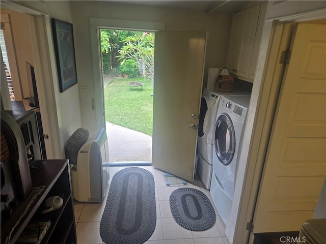 1121 Gladys Ave, Long Beach, CA 90804 - laundry room featuring washing machine and dryer, cabinet space, and light tile patterned flooring