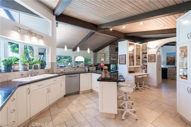 4314 Coronet Dr, Encino, CA 91316 - kitchen with dishwasher, a sink, a breakfast bar area, decorative backsplash, and arched walkways