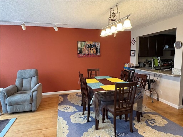 3381 Bandit Cir, Huntington Beach, CA 92649 - dining room featuring track lighting, wood finished floors, and a textured ceiling
