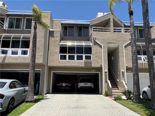 3381 Bandit Cir, Huntington Beach, CA 92649 - townhome / multi-family property featuring a garage, stucco siding, and decorative driveway