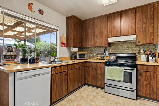4271 Baggett Dr, Riverside, CA 92505 - kitchen featuring dishwasher, stainless steel gas range oven, under cabinet range hood, a sink, and light countertops