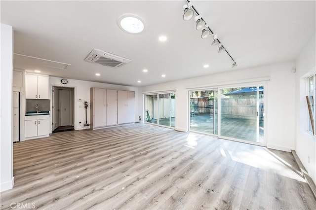 3715 W Birch Ave, Fresno, CA 93711 - unfurnished living room featuring a sink, light wood finished floors, recessed lighting, baseboards, and attic access