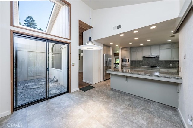 3715 W Birch Ave, Fresno, CA 93711 - kitchen featuring gray cabinetry, stainless steel appliances, baseboards, a peninsula, and a towering ceiling