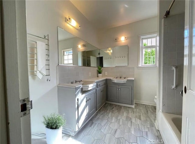 3275 N D St, San Bernardino, CA 92405 - bathroom with double vanity, decorative backsplash, healthy amount of natural light, and toilet