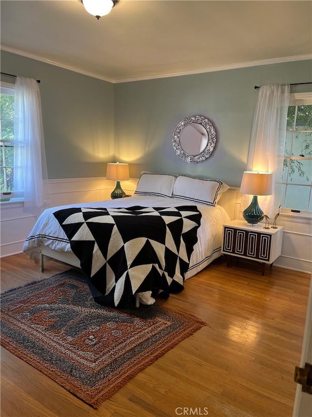 3275 N D St, San Bernardino, CA 92405 - bedroom with wood finished floors, multiple windows, ornamental molding, and a wainscoted wall
