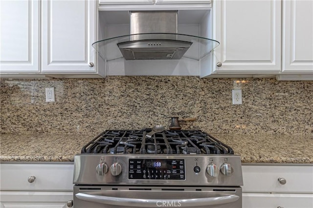 38161 Desert Hawk Dr, Palmdale, CA 93552 - kitchen with wall chimney exhaust hood, stainless steel range with gas stovetop, white cabinetry, light stone counters, and backsplash
