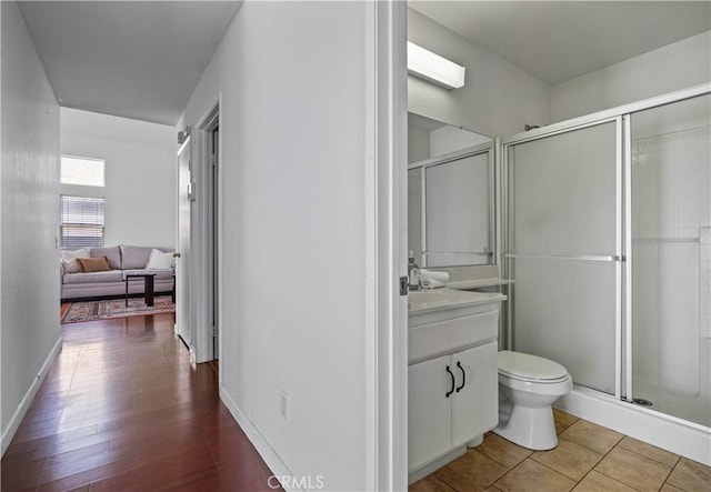 3065 Conestoga Canyon Rd, Palmdale, CA 93550 - bathroom featuring vanity, toilet, a stall shower, baseboards, and wood finished floors