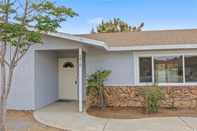 7010 Airway Ave, Yucca Valley, CA 92284 - view of exterior entry with stucco siding, stone siding, and a shingled roof