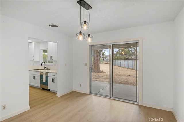 7010 Airway Ave, Yucca Valley, CA 92284 - unfurnished dining area with a sink, light wood-style flooring, and baseboards