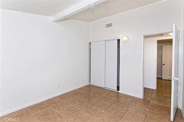 15521 Heartsease Ln, Victorville, CA 92395 - unfurnished bedroom with light tile patterned floors, a closet, and baseboards