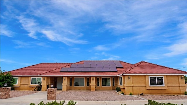 9322 Candlelight St, Apple Valley, CA 92308 - back of property with roof mounted solar panels, driveway, stucco siding, a tile roof, and covered porch
