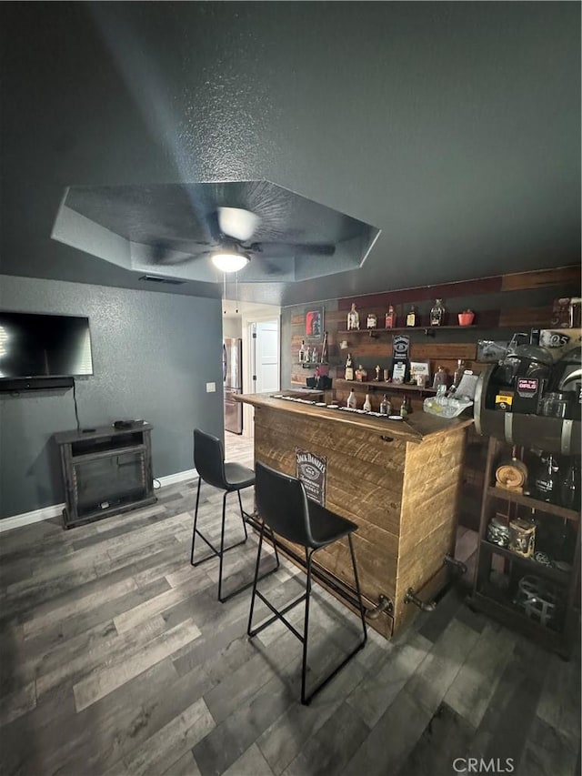 9322 Candlelight St, Apple Valley, CA 92308 - indoor dry bar with a tray ceiling, wood finished floors, a textured wall, and baseboards