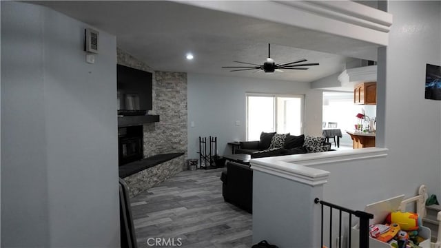 9322 Candlelight St, Apple Valley, CA 92308 - living area with wood finished floors, a ceiling fan, and a fireplace