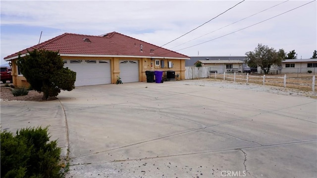 9322 Candlelight St, Apple Valley, CA 92308 - view of home's exterior featuring a tile roof, an attached garage, stucco siding, and driveway