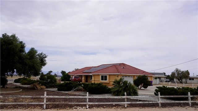 9322 Candlelight St, Apple Valley, CA 92308 - view of front of property featuring gravel driveway, an attached garage, and roof mounted solar panels