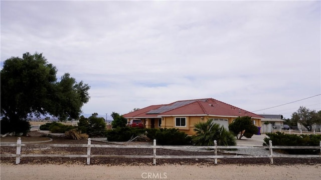 9322 Candlelight St, Apple Valley, CA 92308 - view of front facade featuring a fenced front yard, a garage, roof mounted solar panels, and driveway
