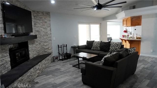 9322 Candlelight St, Apple Valley, CA 92308 - living room with ceiling fan, dark wood-style floors, vaulted ceiling, and a fireplace