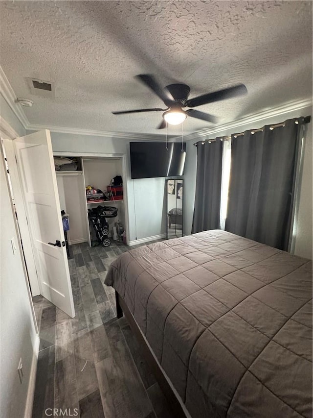 9322 Candlelight St, Apple Valley, CA 92308 - bedroom with ornamental molding, dark wood-style flooring, a textured ceiling, a closet, and a ceiling fan