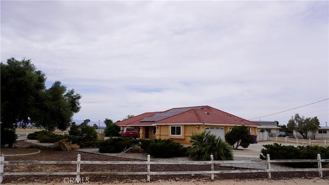 9322 Candlelight St, Apple Valley, CA 92308 - view of front of home with an attached garage, driveway, and roof mounted solar panels
