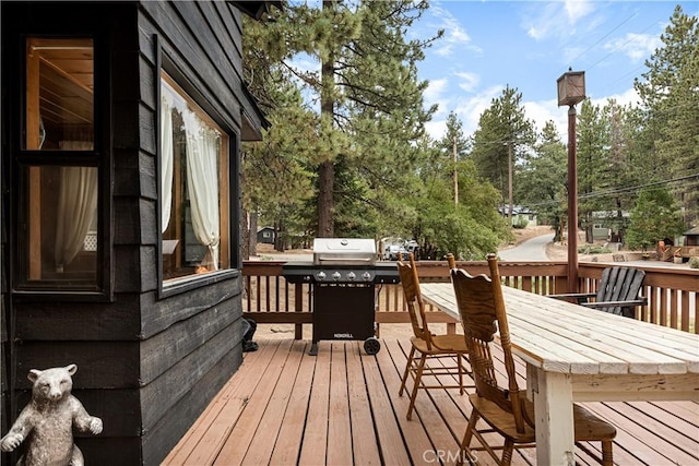 664 Yukon Rd, Green Valley Lake, CA 92341 - deck featuring area for grilling, outdoor dining area, and view of wooded area