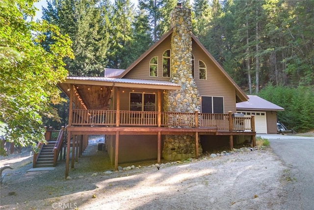 1900 Maple Dr, Weed, CA 96094 - view of front of property featuring driveway, an attached garage, a chimney, stone siding, and stairs