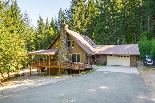 1900 Maple Dr, Weed, CA 96094 - view of front facade with a garage, a wooden deck, driveway, metal roof, and a chimney