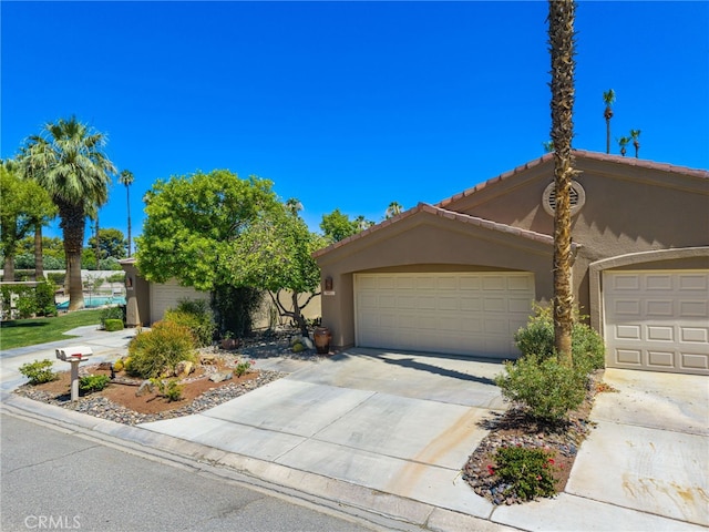 76022 Honeysuckle Dr, Palm Desert, CA 92211 - view of front facade with stucco siding, concrete driveway, an attached garage, and a tiled roof