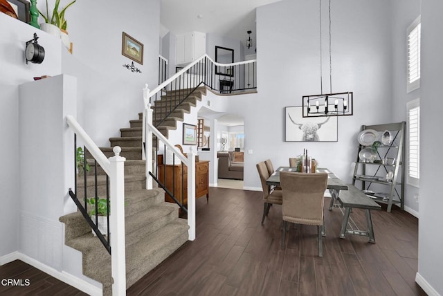 885 Oakland Hills Dr, Banning, CA 92220 - dining area featuring a towering ceiling, stairway, baseboards, wood finished floors, and a chandelier