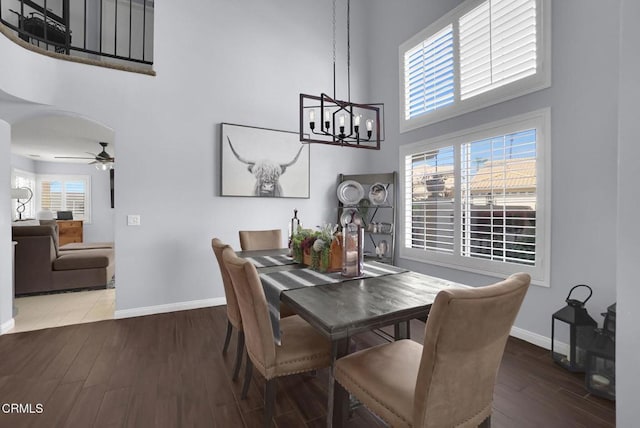 885 Oakland Hills Dr, Banning, CA 92220 - dining space with a towering ceiling, baseboards, wood finished floors, a ceiling fan, and a chandelier