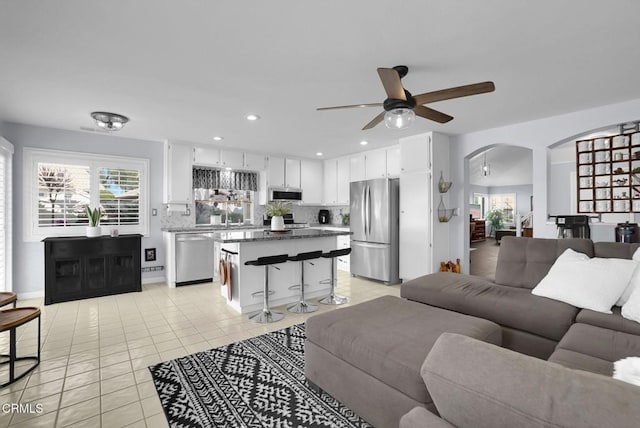 885 Oakland Hills Dr, Banning, CA 92220 - living room with light tile patterned floors, a ceiling fan, arched walkways, and recessed lighting