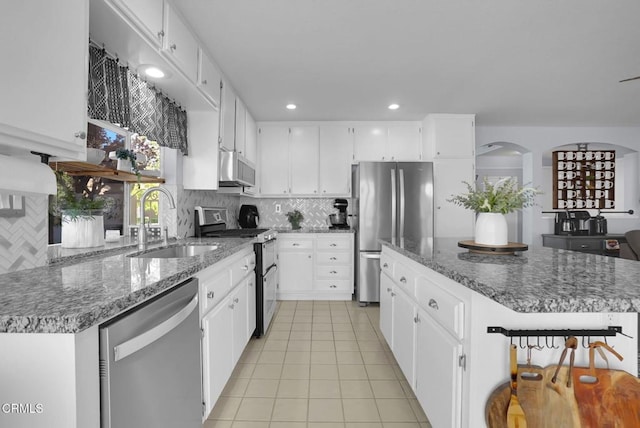 885 Oakland Hills Dr, Banning, CA 92220 - kitchen with stainless steel appliances, a sink, light tile patterned floors, tasteful backsplash, and dark stone counters