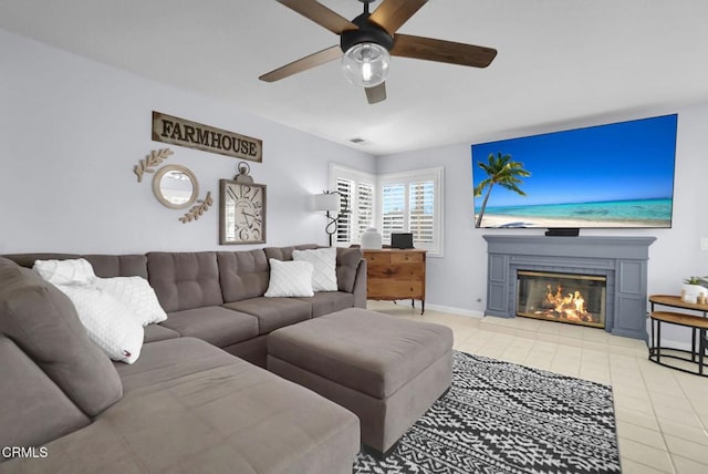 885 Oakland Hills Dr, Banning, CA 92220 - living area featuring a ceiling fan, light tile patterned floors, a glass covered fireplace, and baseboards