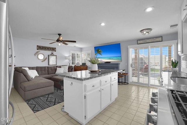 885 Oakland Hills Dr, Banning, CA 92220 - kitchen featuring ceiling fan, a center island, freestanding refrigerator, light tile patterned floors, and white cabinetry
